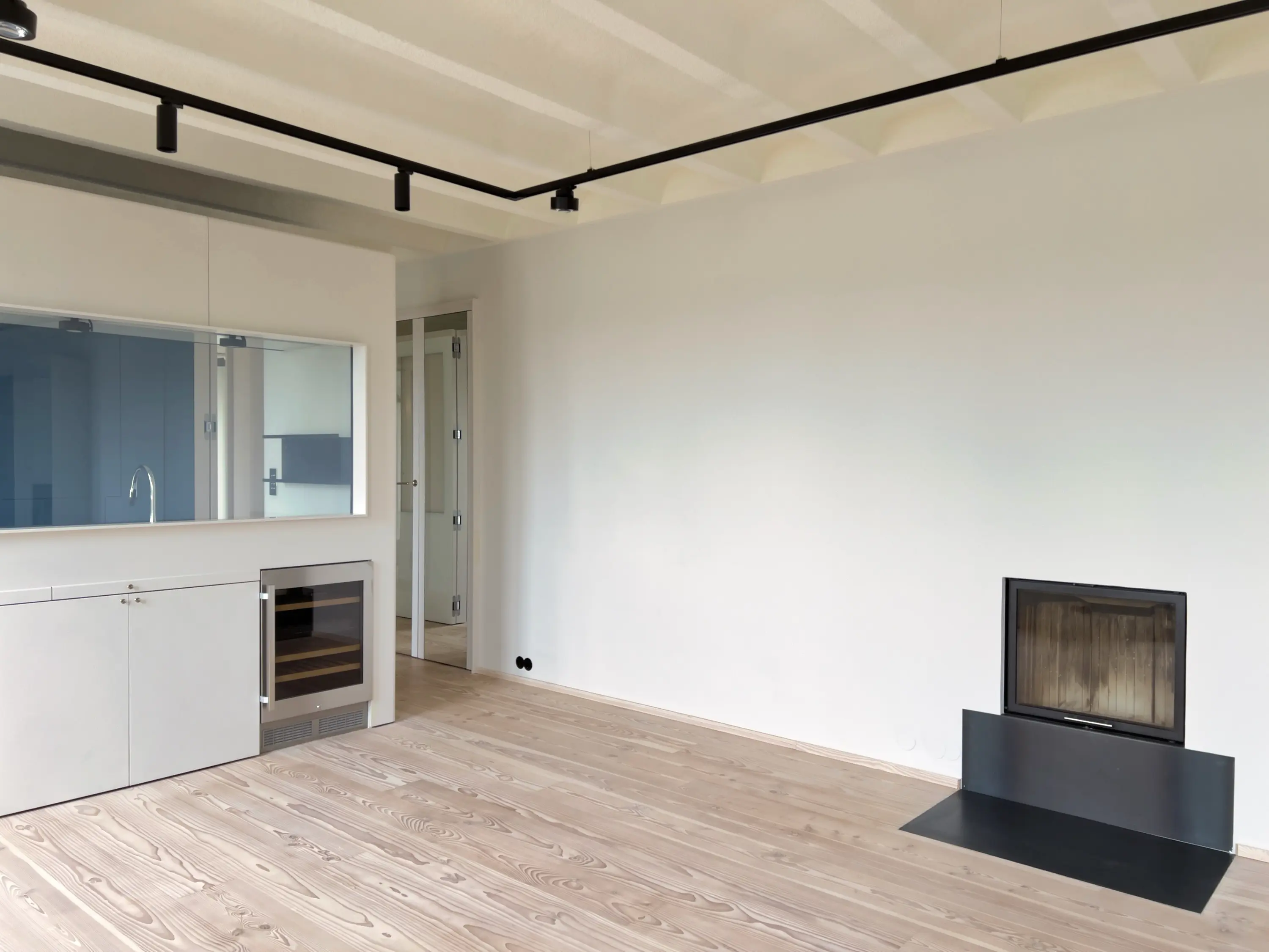 Eckwohnzimmer mit Parkettboden und eingebautem Kamin.